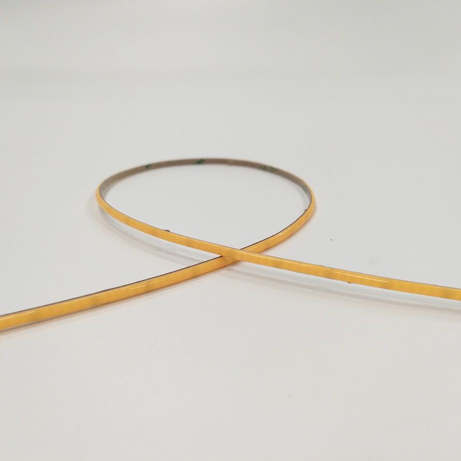 Close-up of an ultra-narrow COB LED strip showing its slim PCB